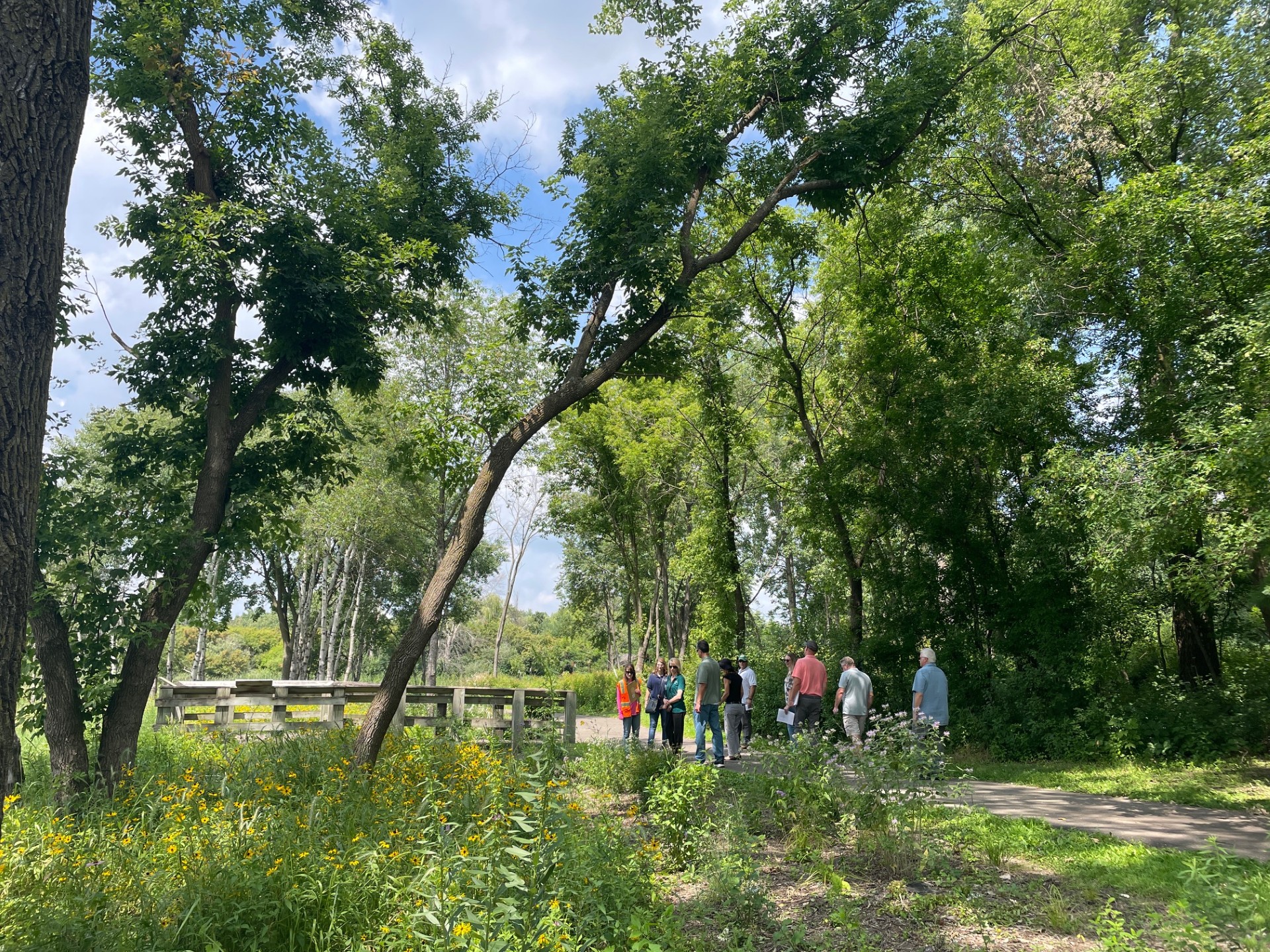 Image slide of Members of VLAWMO's Board of Directors and staff hear from partners about the wetland restoration, summer 2025.